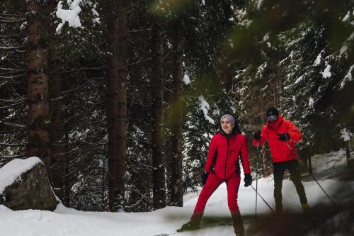 a man and a woman on skis in the snow at Valsegg Chalets Südtirol - luxury and private hideaway in Valles