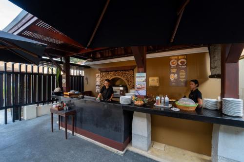 een restaurant met twee mannen die aan een toonbank staan bij Pavilion Samui Villas and Resort - SHA Extra Plus in Lamai