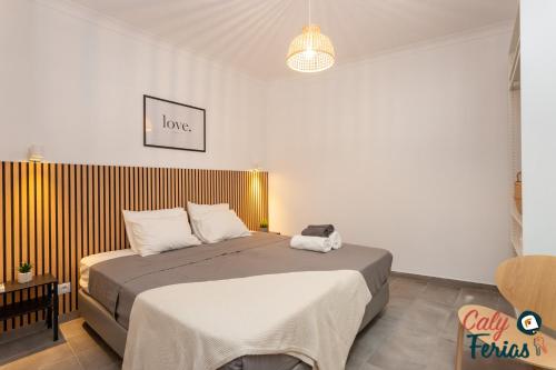 ein Schlafzimmer mit einem großen Bett mit einer braunen Decke in der Unterkunft La petite maison de Armação de Pêra By Calyferias in Armação de Pêra