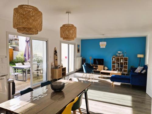 un salon avec une table et un mur bleu dans l'établissement Maison moderne proche plage Morgat, à Crozon