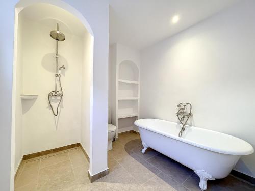 La salle de bains est pourvue d'une baignoire blanche et de toilettes. dans l'établissement Charming villa with pool, ideal family holiday, à Saint-Paul-de-Vence