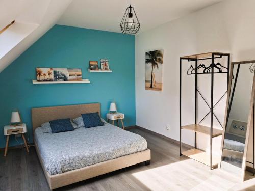une chambre avec un lit et un mur bleu dans l'établissement Maison moderne proche plage Morgat, à Crozon