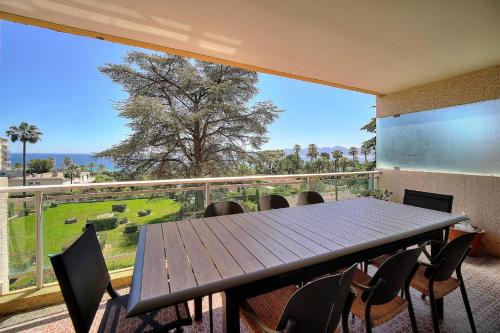 une table et des chaises sur un balcon avec une grande fenêtre dans l'établissement A2B232 Bel appartement vue mer et proche plage, à Cannes