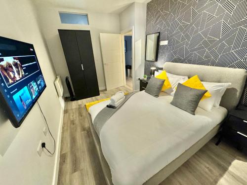 a bedroom with a large bed with a flat screen tv at Two Bedroom Apartment - Heart of Bournemouth - Free Parking - Sleeps 6 - Close to Town and Beach in Bournemouth