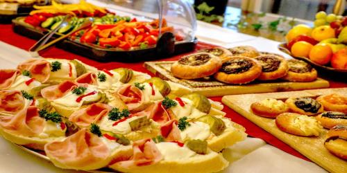 a buffet of food with bread and vegetables on a table at BIRDIE Pension & Wellness in Pardubice