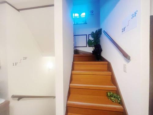a stairway with wooden stairs and a blue wall at Jl千住別荘 in Tokyo