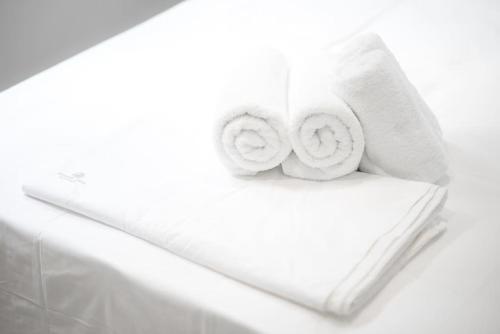 a pile of towels sitting on top of a bed at Villa Redi Relaxing Spa in Piraeus