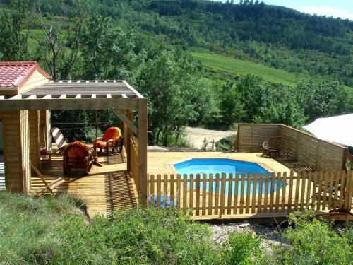 a wooden deck with a swimming pool next to a house at Modern Chalet in Roquetaillade with Swimming Pool in Roquetaillade