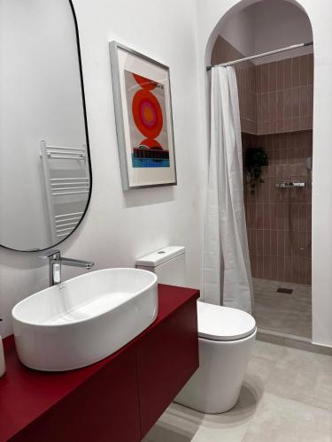 a bathroom with a sink and a toilet and a mirror at Downtown Oasis-City center and Quiet, Self Check in Cluj-Napoca