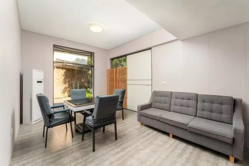 a living room with a couch and a table and chairs at Serene Vale Inn Railway station free pick-up by 2 nights English and Spanish reception available in Guilin