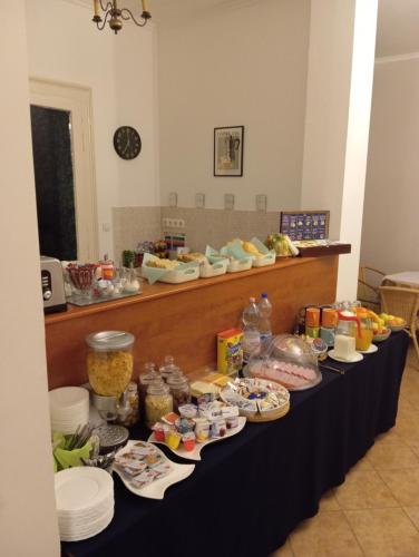 Una mesa larga con platos y comida encima. en Szent Kristóf Apartmanhotel, en Zalaegerszeg