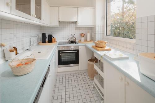 a white kitchen with a sink and a stove at Freywind easy in Norderney
