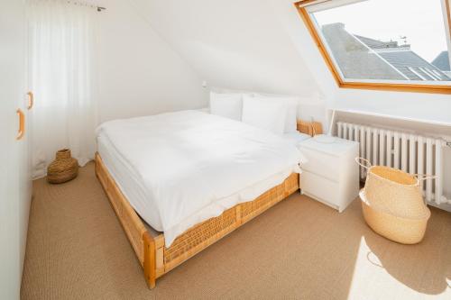 a bedroom with a bed and a window at Freywind easy in Norderney