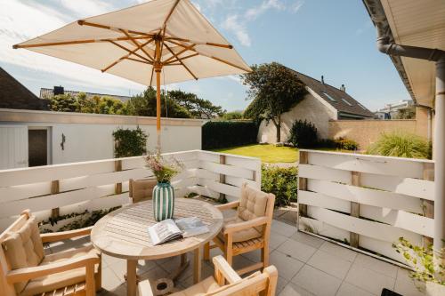 a patio with a table with an umbrella at Freywind easy in Norderney