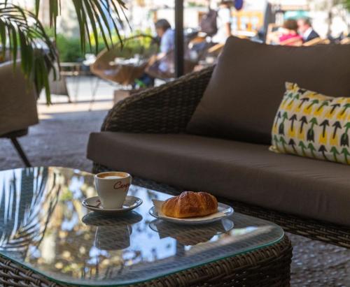 a coffee table with a cup of coffee and a croissant at Hotel Miramar in Port de Soller
