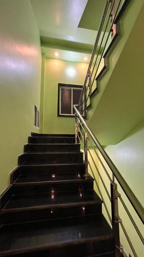 a set of stairs in a building with green walls at Radharani Kutir , Nabadwip in Navadwīp