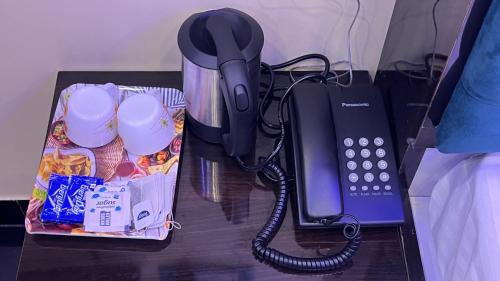 a black phone sitting on a table next to a container at Radharani Kutir , Nabadwip in Navadwīp