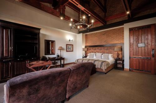 a hotel room with a bed and a couch at Riboville Boutique Hotel And Restaurant in Midrand