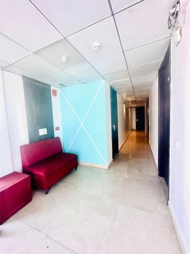 a hallway with a red couch and a blue wall at Hotel Surya Residency in Dehradun