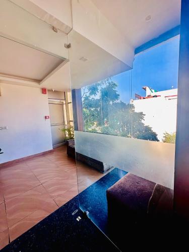 a living room with a large window and a couch at Hotel Surya Residency in Dehradun
