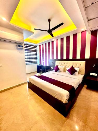 a bedroom with a large bed with a ceiling at Hotel Surya Residency in Dehradun