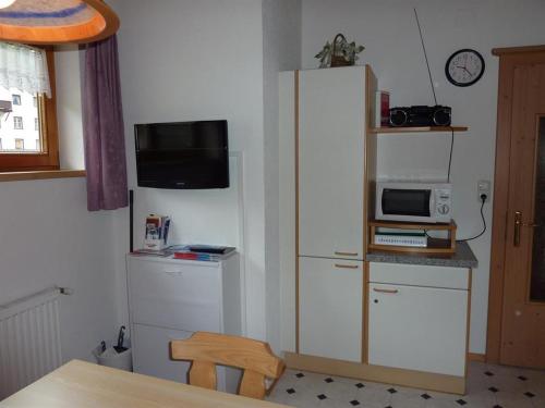 a kitchen with a white refrigerator and a microwave at Appartement Rifflerblick in Pettneu am Arlberg