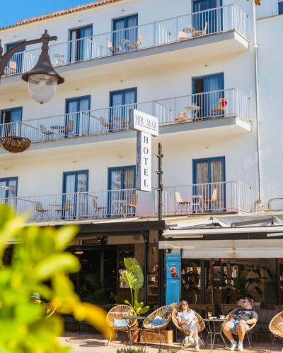 a hotel with tables and chairs in front of a building at Hotel Miramar in Port de Soller