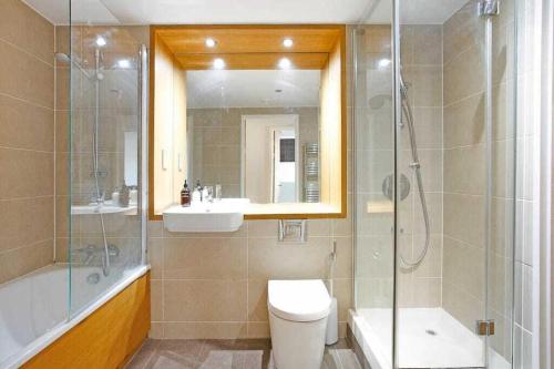 a bathroom with a toilet and a shower and a sink at Auracasa 2 Bed O2 Canning suite in London