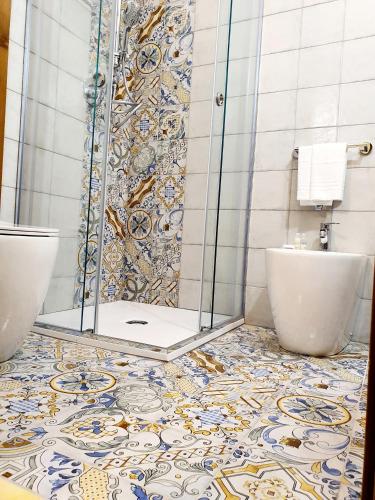 a bathroom with a shower and two toilets at Hotel Cala Marina in Castellammare del Golfo