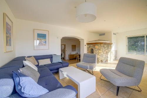 un salon avec un canapé bleu et des chaises dans l'établissement Villa rénovée- Vue mer- Centre de Cannes, à Cannes