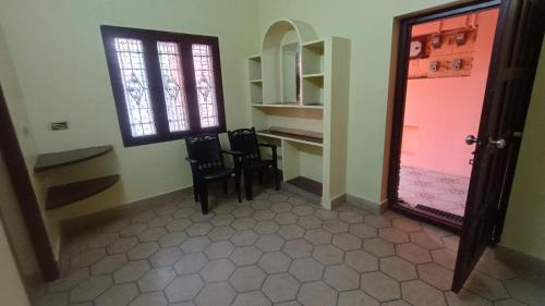 a room with two chairs and a table and a door at Sri BALAJI homestay Guest house in Tiruvannāmalai