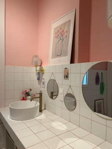 une salle de bain avec un lavabo et un miroir dans l'établissement L'etage-30m2 au coeur d'un immeuble haussmannien, à Sète
