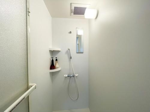 a bathroom with a shower in a white wall at Niseko White Villas I in Kombu