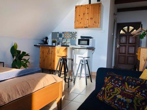 a bedroom with a bed and a kitchen with a microwave at Repülőhal Apartmanház in Zebegény