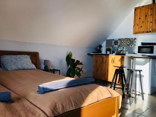 a bedroom with a large bed and a kitchen at Repülőhal Apartmanház in Zebegény
