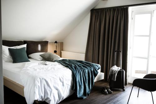 a bedroom with a bed and a window at Hotel Weisses Kreuz in Malles Venosta