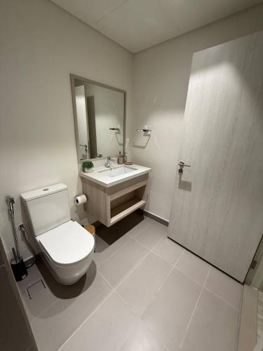 a bathroom with a toilet and a sink and a mirror at 4br Luxury Villa Yas Island Near F1 in Abu Dhabi