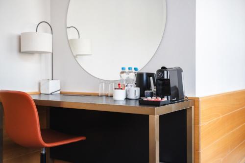 a desk with a coffee maker on it with a chair at K+K Hotel Fenix in Prague