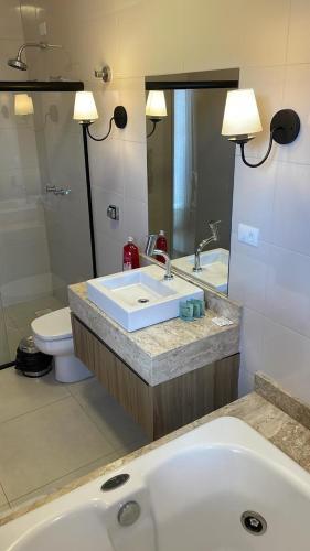 a bathroom with a sink and a toilet at Hotel Eden in Eugênio Penzo