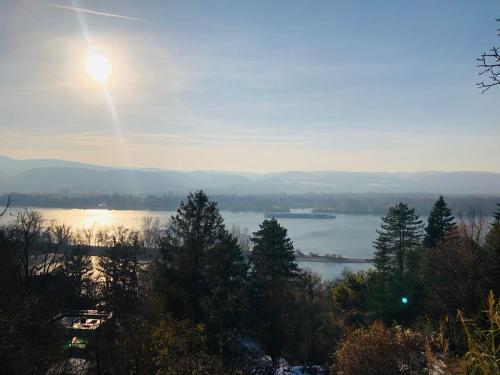 a view of a river with the sun in the sky at Repülőhal Apartmanház in Zebegény