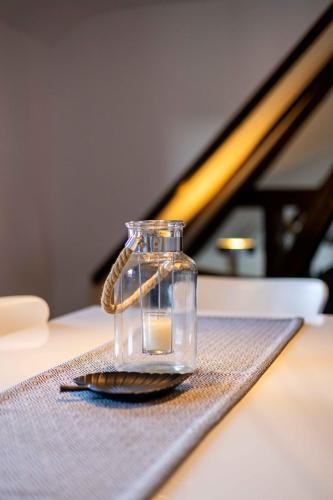 a glass jar with a candle in it on a table at Ferienwohnung "Kino" in Bad Gandersheim