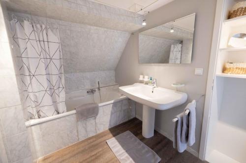 a bathroom with a sink and a tub and a mirror at Ferienwohnung "Kino" in Bad Gandersheim
