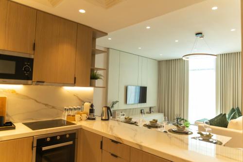 a kitchen with wooden cabinets and a counter top at Pearlhouse Bahrain in Manama
