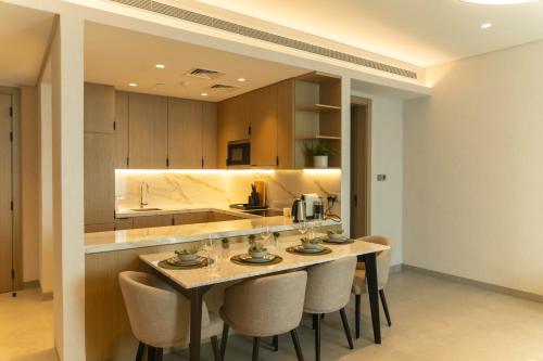 a kitchen with a table and chairs in a room at Pearlhouse Bahrain in Manama