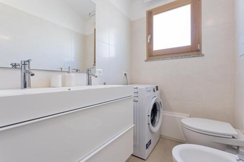 une salle de bain blanche avec une machine à laver à l'intérieur dans l'établissement Casa dell'Alba Dorata, à Tertenìa