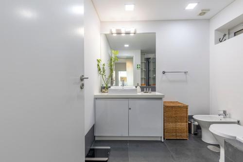 a white bathroom with a sink and a mirror at Cliffs Apartment - Astonishing view over Sesimbra bay by Trip2Portugal in Sesimbra
