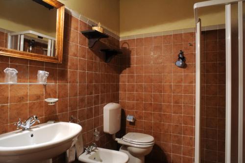 a bathroom with a sink and a toilet and a mirror at I Costanti in Caldiero