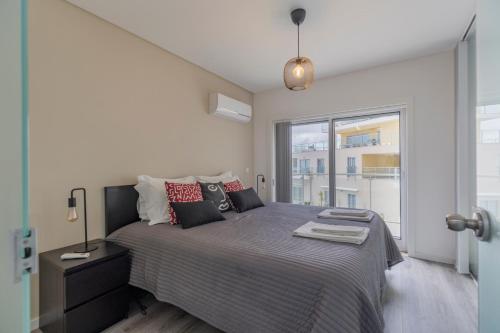 a bedroom with a bed and a large window at Cliffs Apartment - Astonishing view over Sesimbra bay by Trip2Portugal in Sesimbra