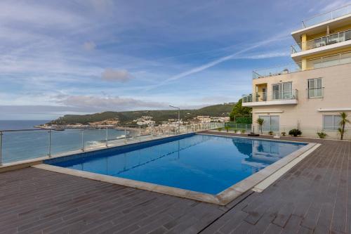 a swimming pool with a view of the ocean at Cliffs Apartment - Astonishing view over Sesimbra bay by Trip2Portugal in Sesimbra