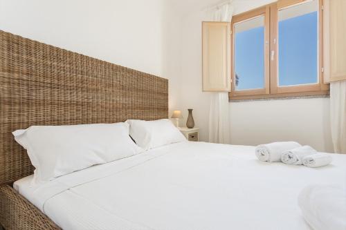 une chambre avec un lit blanc avec des serviettes dessus dans l'établissement Casa dell'Alba Dorata, à Tertenìa